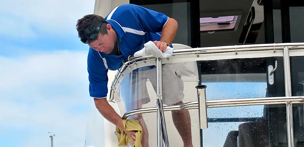Hand-polishing the brightwork of a flybridge cruiser